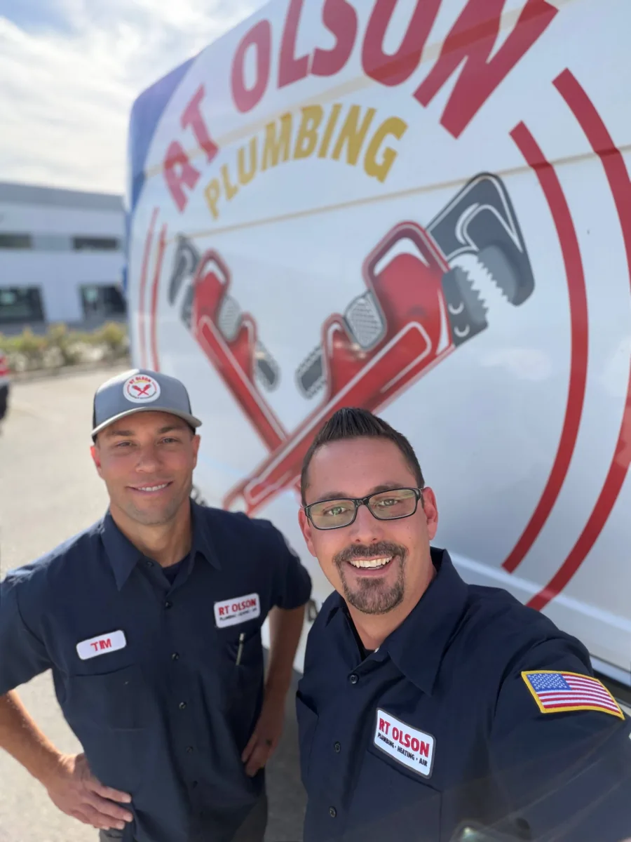 RT Olson Plumbing, Heating and Air Conditioning technicians in front of a branded service van