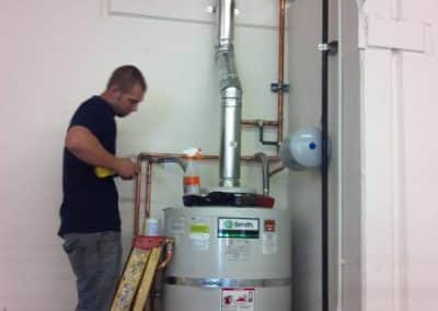 RT Olson plumber working on a water heater