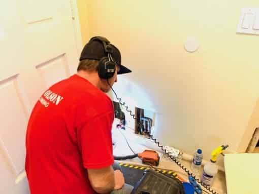 RT Olson plumber using leak detection equipment