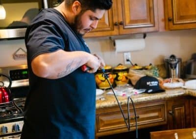 plumber at work in kitchen sink