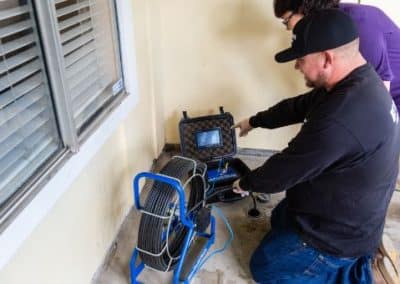 video camera drain inspection equipment being shown by one plumber to another