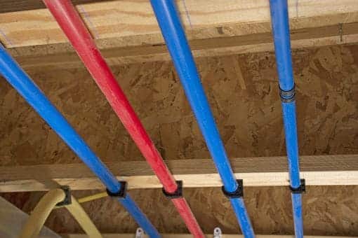 red and blue PEX pipe running in attic