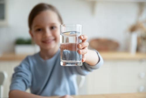 girl holding glass of clean filtered water